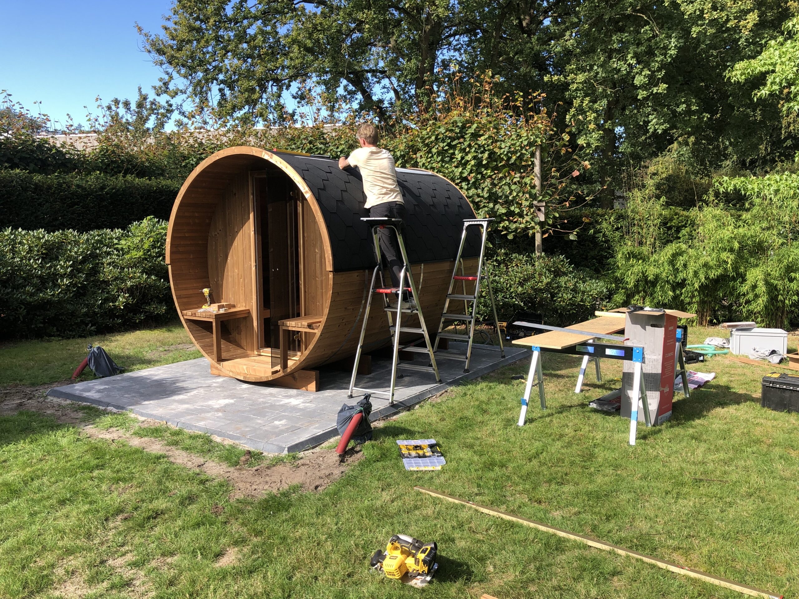 Ons bouwteam bouwt een barrelsauna op in een tuin
